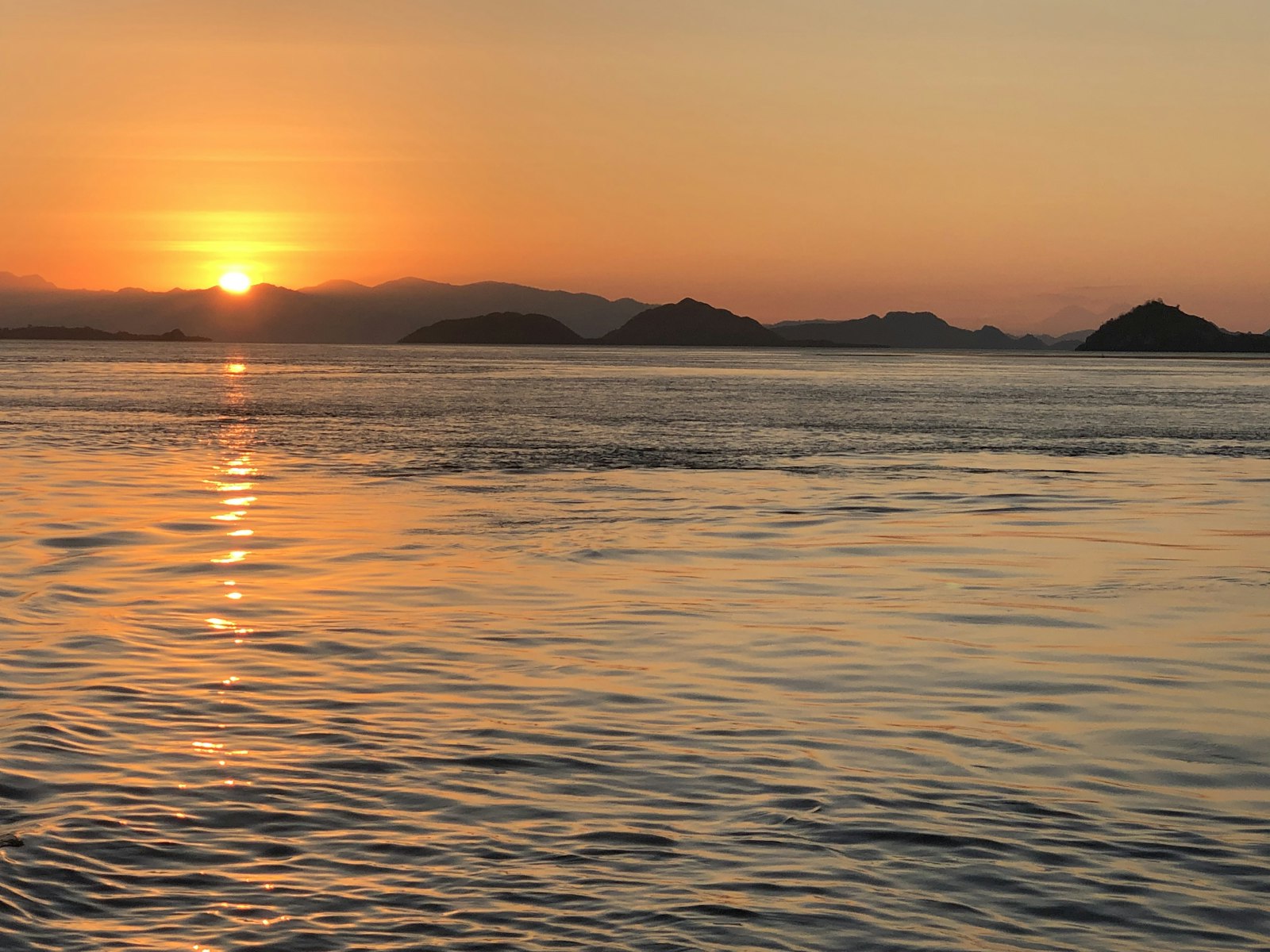 the sun is setting over a body of water